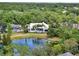 Stunning aerial shot of the property highlighting a gorgeous pool, lake and lush surroundings at 9364 Thurloe Pl, Orlando, FL 32827