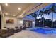 Inviting backyard with a pool, covered patio, comfortable seating, and lush palm trees at 9364 Thurloe Pl, Orlando, FL 32827