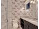 Bathroom with granite countertops, framed mirrors, shower, toilet, and decorative wallpaper at 9364 Thurloe Pl, Orlando, FL 32827