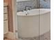 Elegant soaking tub with modern fixtures and stone tile surround at 9364 Thurloe Pl, Orlando, FL 32827