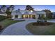 Beautiful home showcasing a circular driveway, well-maintained landscaping, and warm exterior lighting at 9364 Thurloe Pl, Orlando, FL 32827