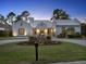 Beautiful front exterior with lush landscaping, circular driveway, and elegant lighting at 9364 Thurloe Pl, Orlando, FL 32827