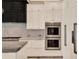 Modern kitchen featuring stainless steel appliances, marble countertops, and a double oven at 9364 Thurloe Pl, Orlando, FL 32827