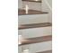 Staircase features dark wood steps and white risers, creating a modern, well-lit look at 9364 Thurloe Pl, Orlando, FL 32827