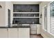 A wet bar showcasing a built-in microwave, a stainless steel wine cooler, and floating shelves at 9364 Thurloe Pl, Orlando, FL 32827