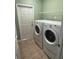 Convenient laundry room featuring a washer, dryer, and wire shelving at 10414 Andover Point Cir, Orlando, FL 32825