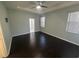 Bright main bedroom featuring dark wood floors, tray ceilings, and a ceiling fan at 10414 Andover Point Cir, Orlando, FL 32825