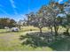 Aerial view of a large property with a metal carport, mature trees, and fenced pasture at 1072 Se 155Th St, Summerfield, FL 34491