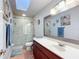 Well-lit bathroom featuring a glass shower, vanity with mirror, and tiled flooring at 1072 Se 155Th St, Summerfield, FL 34491