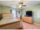 Inviting bedroom featuring a ceiling fan, light green walls, and wood-look tile flooring at 1072 Se 155Th St, Summerfield, FL 34491