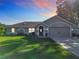 Charming one-story home with a well-manicured lawn and an attached two-car garage, enhanced by a twilight sky at 1072 Se 155Th St, Summerfield, FL 34491