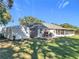 Beautiful home exterior with a shed, outdoor brick oven, patio, screened-in porch, and lush green lawn at 1072 Se 155Th St, Summerfield, FL 34491