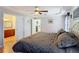 Bright main bedroom featuring a tray ceiling, ceiling fan, and adjoining bathroom and walk-in closet at 1072 Se 155Th St, Summerfield, FL 34491