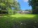 Spacious backyard with lush green lawn, mature trees, and a patio area at 11056 Clipper Ct, Windermere, FL 34786
