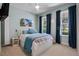 Serene bedroom features a bed with blue accents, carpeted floors, and natural light from the windows at 11407 Wakeworth St, Orlando, FL 32836