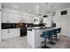 Modern kitchen with a breakfast bar, white cabinetry, and sleek black countertops at 11407 Wakeworth St, Orlando, FL 32836