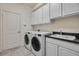 Efficient laundry room featuring a washer, dryer, sink, and ample cabinet storage at 11407 Wakeworth St, Orlando, FL 32836
