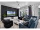 Inviting living room featuring a modern accent wall, stylish furniture, and plenty of natural light at 11407 Wakeworth St, Orlando, FL 32836