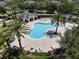 Aerial view of community pool with a unique shape, surrounded by palm trees and lounge chairs at 11407 Wakeworth St, Orlando, FL 32836