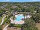 Aerial view of the community pool surrounded by mature trees, lounge seating and shade cabanas at 11407 Wakeworth St, Orlando, FL 32836