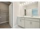 Elegant bathroom featuring double sinks, white shaker cabinets, tile floors, and walk-in closet at 11941 Bracco St, Winter Garden, FL 34787