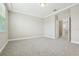 A neutral bedroom with plush carpet flooring, crown molding, and multiple doorways at 11941 Bracco St, Winter Garden, FL 34787