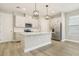 Modern kitchen featuring stainless steel appliances, white cabinets, a central island, and stylish pendant lighting at 11941 Bracco St, Winter Garden, FL 34787
