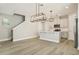 Open concept kitchen featuring stainless appliances, white cabinets, and an island overlooking living area with stairs at 11941 Bracco St, Winter Garden, FL 34787