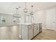 Well-lit kitchen featuring a central island with a sink, stainless steel appliances, and modern pendant lights at 11941 Bracco St, Winter Garden, FL 34787