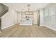Spacious living area with hardwood floors and view of modern kitchen with stainless steel appliances at 11941 Bracco St, Winter Garden, FL 34787