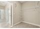 Carpeted walk-in closet with ample shelving and neutral walls is ready for organizing all your clothes and shoes at 11941 Bracco St, Winter Garden, FL 34787
