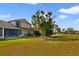 Large backyard with mature trees, a screened in patio, and a well-maintained lawn at 12133 Augusta Woods Cir, Orlando, FL 32824