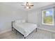 Cozy bedroom with wood-look flooring, ceiling fan, and a window providing natural light at 12133 Augusta Woods Cir, Orlando, FL 32824