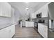 The kitchen has white cabinets, stainless steel appliances, and a view of the living area at 12133 Augusta Woods Cir, Orlando, FL 32824