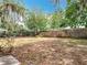 A well-maintained backyard featuring mature trees and a privacy fence at 130 Aragon Ave, Umatilla, FL 32784
