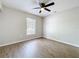 Bedroom featuring modern ceiling fan, window bringing in natural light and wood-look flooring at 130 Aragon Ave, Umatilla, FL 32784