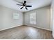 Bedroom featuring modern ceiling fan, windows bringing in natural light and wood-look flooring at 130 Aragon Ave, Umatilla, FL 32784