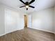 The bedroom has a ceiling fan, wood-look floors, closet, and neutral paint at 130 Aragon Ave, Umatilla, FL 32784