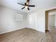 This bedroom has a ceiling fan, wood-look flooring and a closet with white doors at 130 Aragon Ave, Umatilla, FL 32784