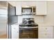 Well-equipped kitchen with stainless steel appliances, a range, and white cabinetry at 130 Aragon Ave, Umatilla, FL 32784