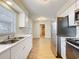 Bright kitchen features stainless steel appliances, double bowl sink and white cabinets with light countertops at 130 Aragon Ave, Umatilla, FL 32784