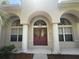 Elegant front entrance with arched doorway and manicured landscaping at 13250 Meergate Cir, Orlando, FL 32837