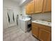 Bright laundry room with washer, dryer, utility sink, and upper cabinets at 13250 Meergate Cir, Orlando, FL 32837