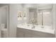 Bathroom featuring a double sink vanity, white countertops, and framed mirrors at 13271 Pergola Ave, Orlando, FL 32832