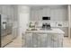 Modern kitchen featuring a large island, stainless steel appliances, and gray cabinets at 13271 Pergola Ave, Orlando, FL 32832