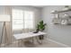 Bright home office featuring a stylish marble desk, comfortable chair, and floating shelves with tasteful decor at 13271 Pergola Ave, Orlando, FL 32832