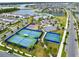 An aerial view shows a community park with basketball and tennis courts near a waterway at 13807 Tybee Beach Ln, Orlando, FL 32827