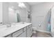 Bright bathroom with double vanity, framed mirror, and a shower/tub combo with colorful curtain at 13807 Tybee Beach Ln, Orlando, FL 32827