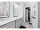Bathroom featuring double sinks, gray vanity, and access to a walk-in closet and shower at 13807 Tybee Beach Ln, Orlando, FL 32827