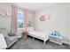 Cozy bedroom with pink decor, a twin bed, gray chair, and a window with natural light at 13807 Tybee Beach Ln, Orlando, FL 32827